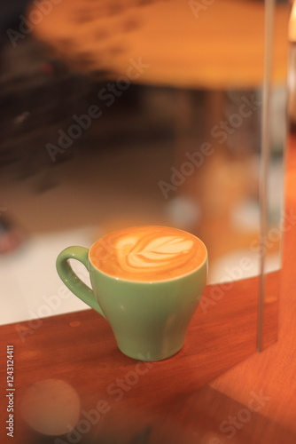Green Coffee Cup Holds Latte Art, Aroma, and Warmth Delightfully on a Wooden Surface