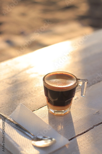 Morning Coffee Sits on Table with Spoon and Napkin at Sunrise