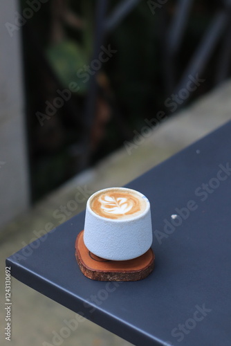 Coffee Cup Sits on Table with Latte Art and Rustic Wooden Coaster Perfectly