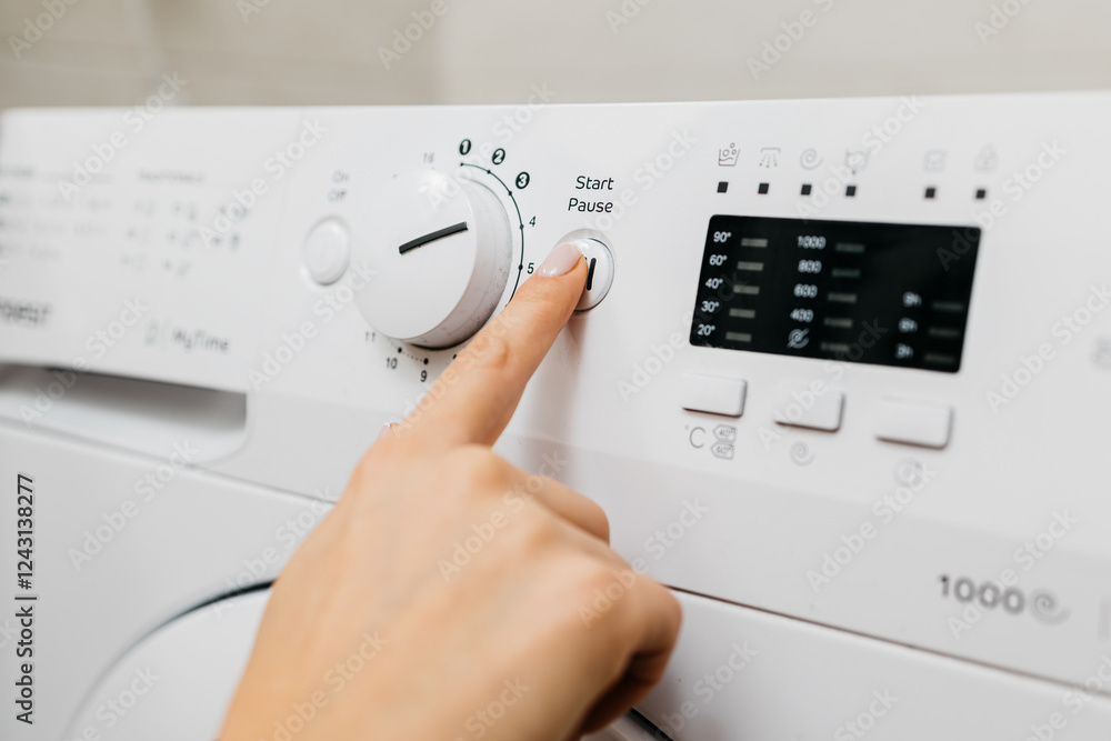 A woman loads dirty laundry into the washing machine and sets the wash cycle. Concept: caring for cleanliness and comfort at home, simplifying daily life with modern technology. A woman loads dirty laundry into the washing machine and sets the wash cycle. Concept: caring for cleanliness and comfort at home, simplifying daily life with modern technology.