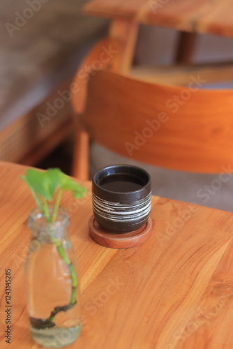 Cozy Cafe Corner: Coffee, Wood Table, Plant Decor Creates Relaxing Ambiance Quietly and Peacefully.