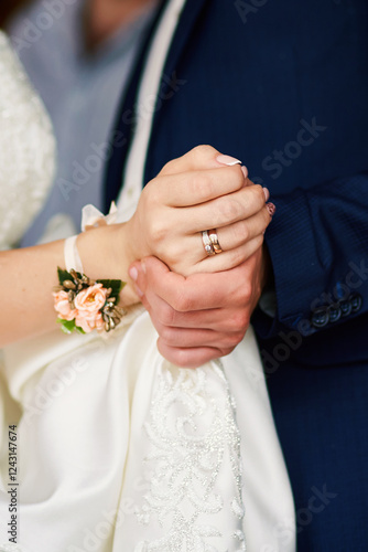 Vertical photo of newlyweds holding each other's hands during a dance