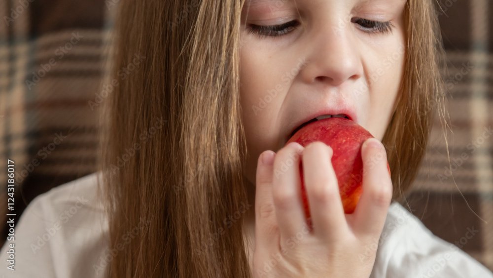 Happy little girl eating apple sitting on the sofa living-room Happy little girl eating apple sitting on the sofa living-room