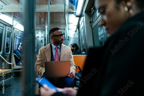 Photography Businessman working on laptop on subway commuting home