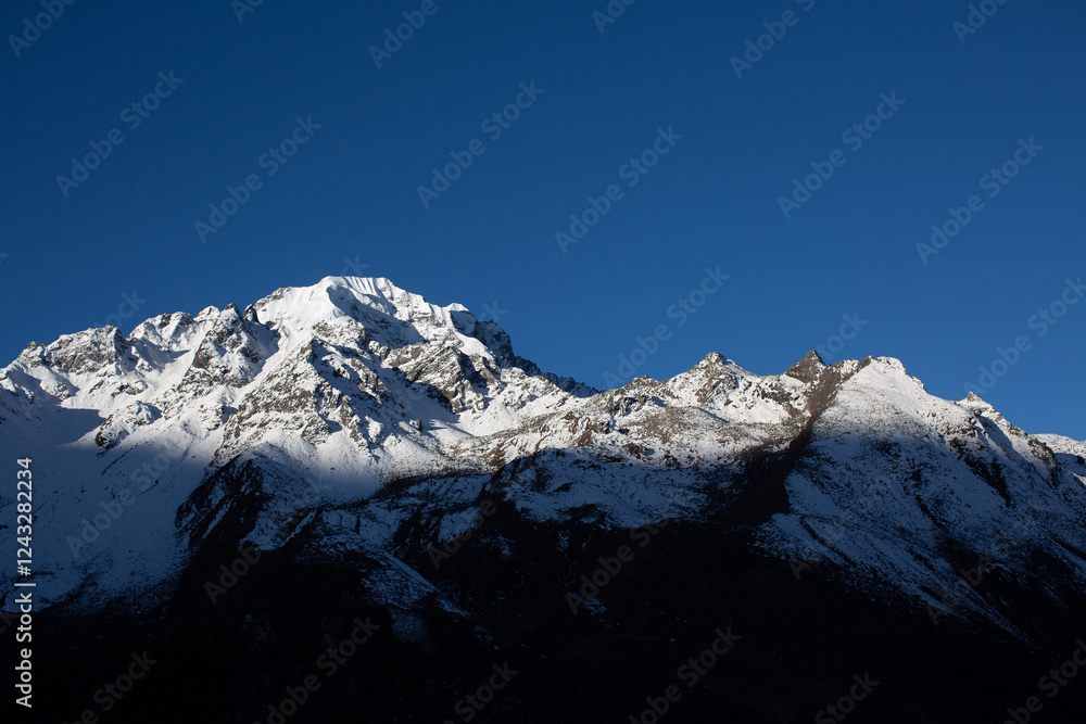 Obraz premium A mountain covered in snow with a cloud in the sky