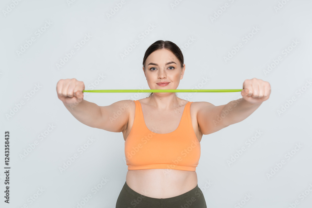 Strong and confident female athlete stretching resistance band in modern fitness studio Strong and confident female athlete stretching resistance band in modern fitness studio