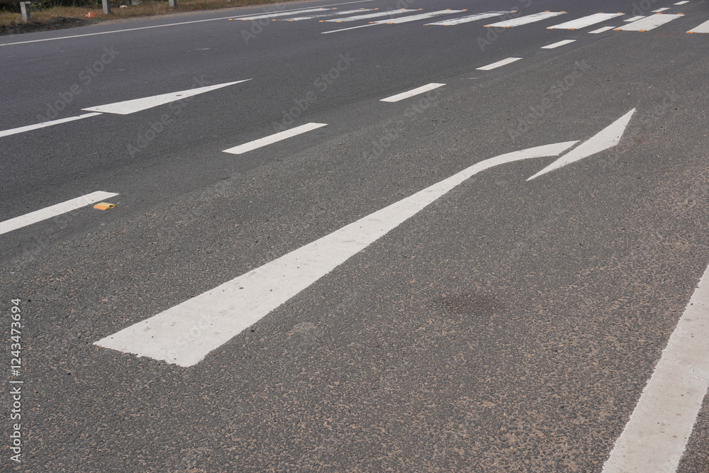 The road markings indicating a right turn ahead which is promoting safety by clearly showing drivers where to position their vehicles for turning The road markings indicating a right turn ahead which is promoting safety by clearly showing drivers where to position their vehicles for turning