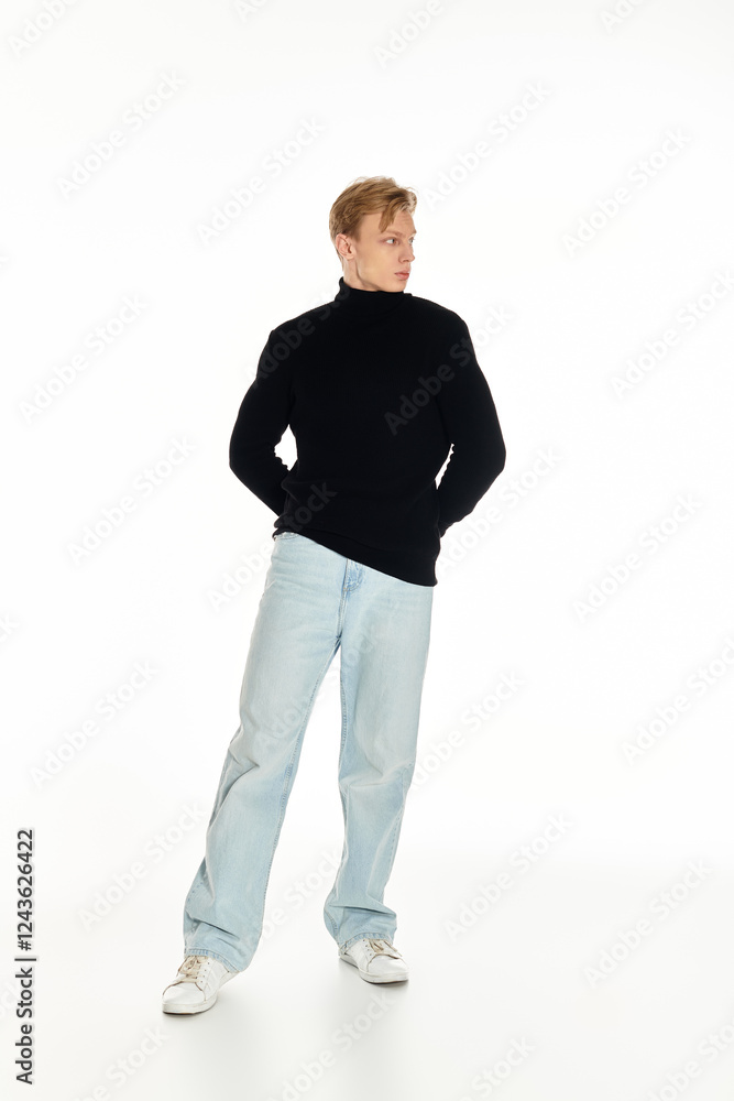 Fototapeta premium Young handsome man in stylish attire posing confidently with casual elegance in a bright studio