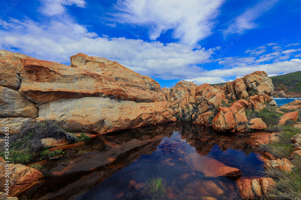 Rocky coastal landscape in South Africa with clear sky and calm water reflections Rocky coastal landscape in South Africa with clear sky and calm water reflections