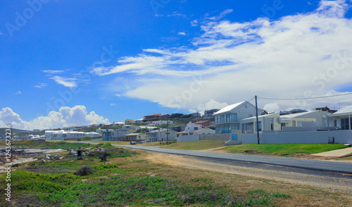 Coastal road view with homes along the shore near South African coastline during daytime