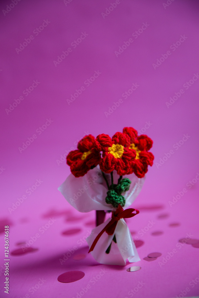 Fototapeta premium A bouquet of red knitted flowers on a beautiful background, a bouquet of red flowers, knitted flowers, knitted bouquets, handmade, knitted flowers, knitted gifts and toys