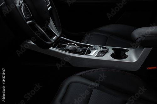 A black car interior with a steering wheel and a cup holder