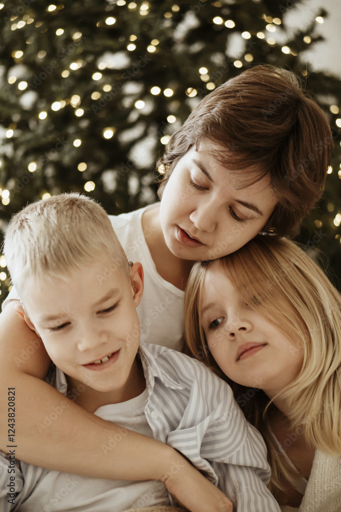 A loving mother with her son and daughter enjoys the magical atmosphere of Christmas and New Year. The family shares joyful moments, playing together, laughing, and creating warm holiday memories A loving mother with her son and daughter enjoys the magical atmosphere of Christmas and New Year. The family shares joyful moments, playing together, laughing, and creating warm holiday memories