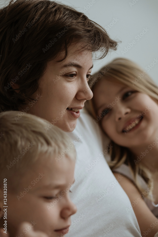 A loving mother with her son and daughter enjoys the magical atmosphere of Christmas and New Year. The family shares joyful moments, playing together, laughing, and creating warm holiday memories A loving mother with her son and daughter enjoys the magical atmosphere of Christmas and New Year. The family shares joyful moments, playing together, laughing, and creating warm holiday memories