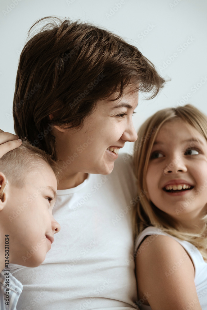 A loving mother with her son and daughter enjoys the magical atmosphere of Christmas and New Year. The family shares joyful moments, playing together, laughing, and creating warm holiday memories A loving mother with her son and daughter enjoys the magical atmosphere of Christmas and New Year. The family shares joyful moments, playing together, laughing, and creating warm holiday memories