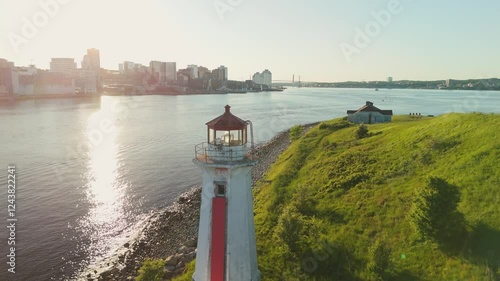 A Beautiful Aerial View Of An Ancient Lighthouse Standing On A Small Island In Halifax Harbor, Nova Scotia. The Sunset Paints The Sky With Vibrant Colors, Adding Magic To This Scenic Landmark.