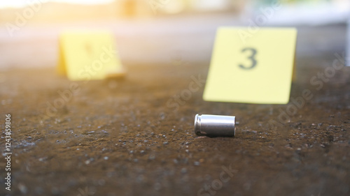 A spent bullet casing in focus, with a blurred forensic number 3 tag behind it, symbolizes crime scene investigation, evidence collection, and law enforcement efforts in forensic science.
