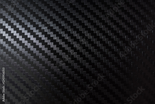 Carbon fiber composite raw material background. Carbon fiber texture. Dark Gray background with lighting.