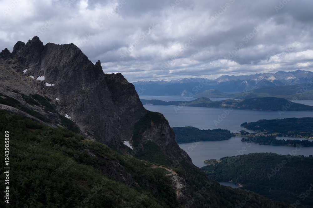 Fototapeta premium Patagonian landscape. Panorama view of the rocky mountains, forest and Nahuel Huapi lake under a cloudy sky, seen from high in Cerro Lopez