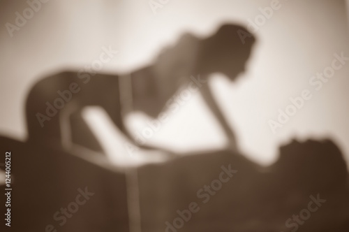 Blurred background. Silhouettes of a couple in love. A man and a woman are making love.
