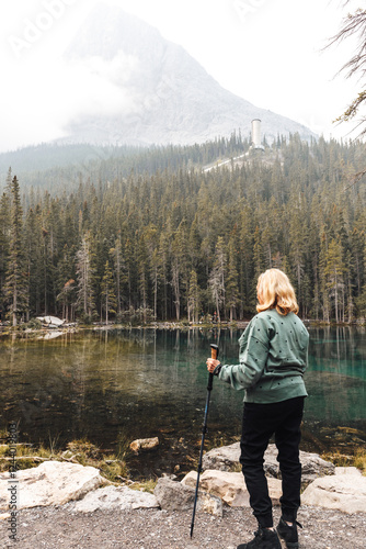 Mature woman standing by a lake in the mountains on a hazy day