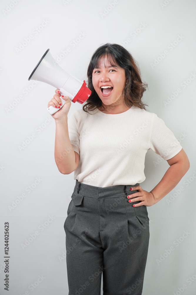 Beautiful young asian woman with wavy hair wearing white shirt is shouting using a megaphone, isolated over white background. Beautiful young asian woman with wavy hair wearing white shirt is shouting using a megaphone, isolated over white background.