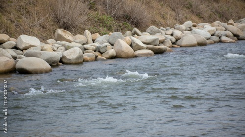Scenic Riverbank with Smooth Stones and Gentle Water Current