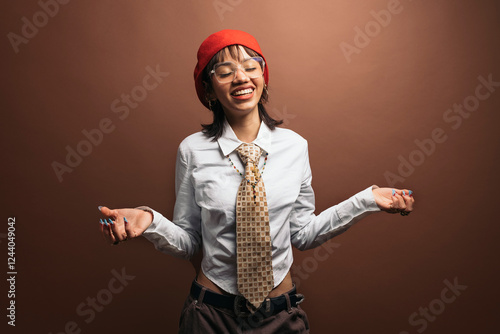 Stylish woman wearing beret and tie is smiling with closed eyes photo