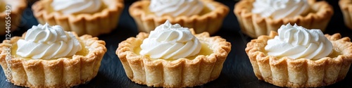 A close-up shot of a tray filled with assorted pies topped with fluffy whipped cream photo