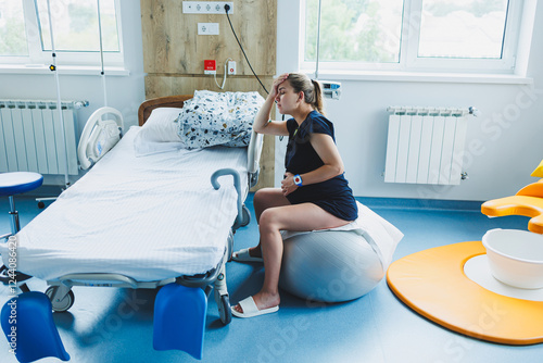 Obraz na płótnie A woman in the delivery room feels contractions and severe pain in her lower abdomen. Pain during childbirth. w salonie