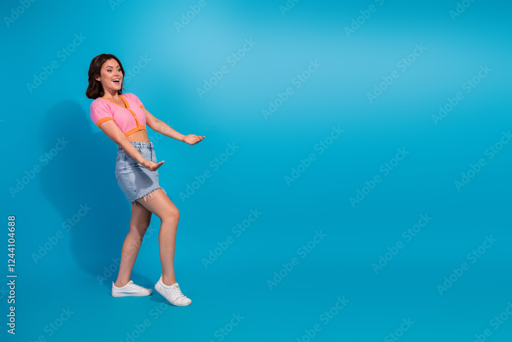 Charming young woman in casual style against vibrant blue background showcasing a cheerful attitude Charming young woman in casual style against vibrant blue background showcasing a cheerful attitude