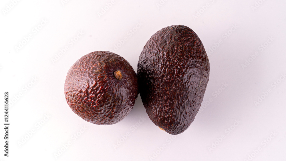Two avocados are sitting on a white background. The avocados are ripe and ready to eat Two avocados are sitting on a white background. The avocados are ripe and ready to eat