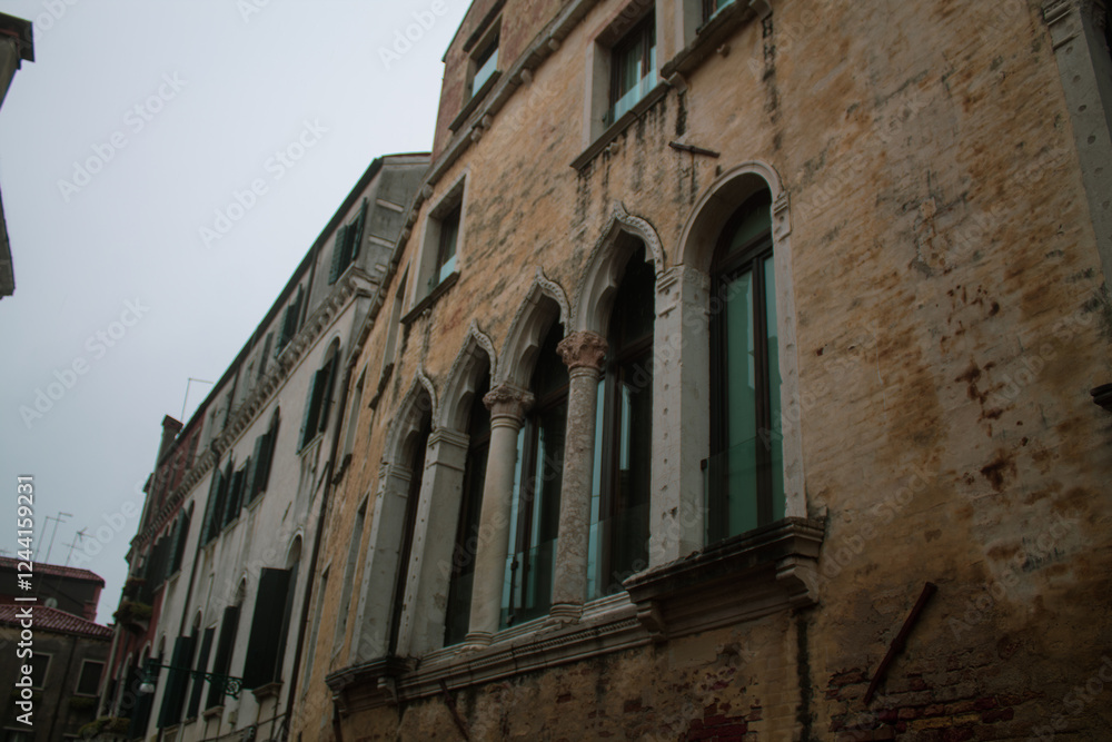 Fototapeta premium Carved Gothic windows on ancient residential house stone building of Venetian streets, Venice, Italy