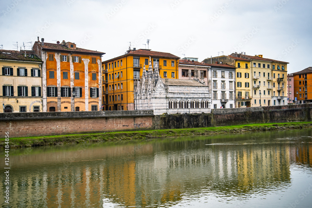 Fototapeta premium View on Arno river and colorful building, reflection in water, Pisa, Italy