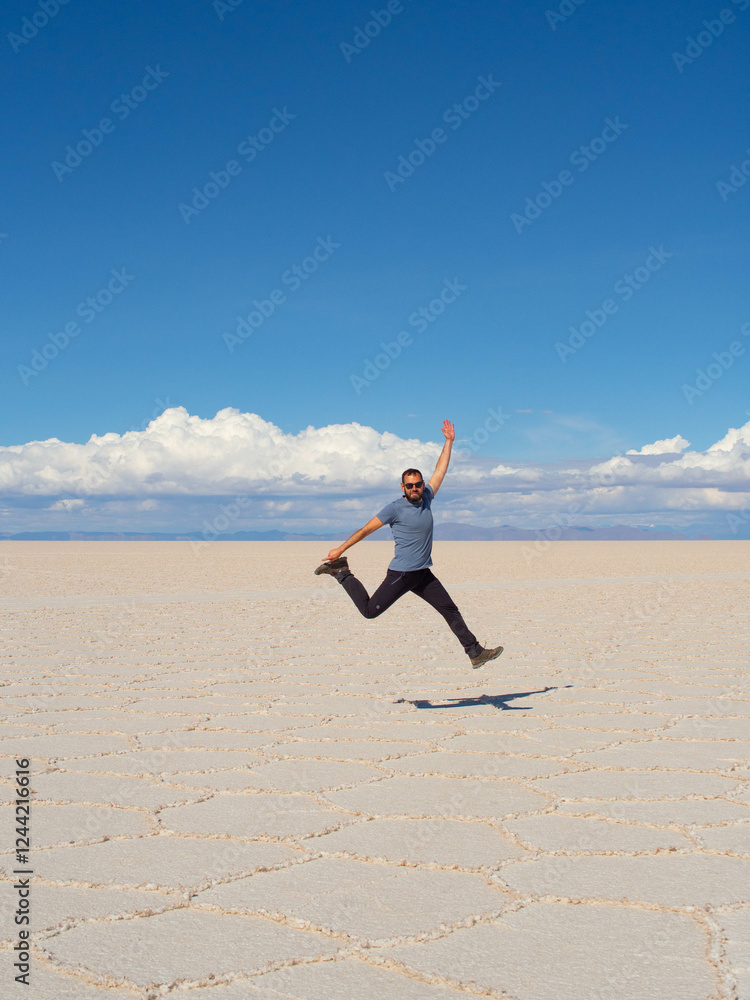 traveler man jumping on the salt surface of Uyuni salt flat in Bolivia traveler man jumping on the salt surface of Uyuni salt flat in Bolivia