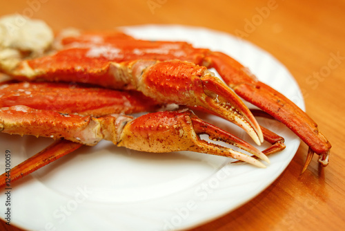 boiled crab claws and limbs arranged on a white ceramic plate, showcasing their vibrant color and texture, perfect for seafood culinary themes photo