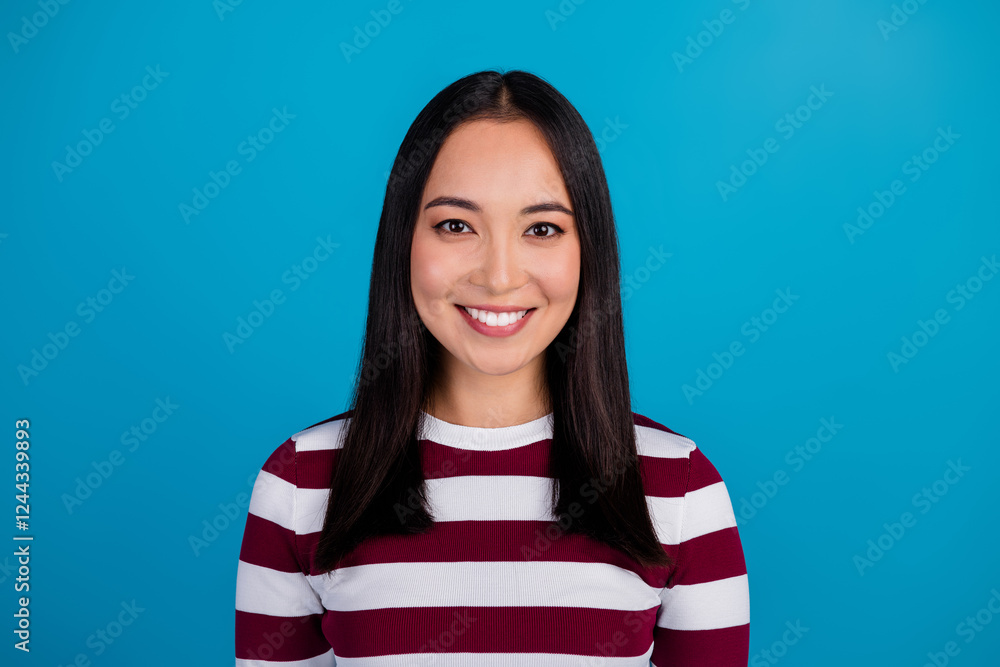 Portrait of a young woman in a striped shirt smiling against a blue background, showcasing a cheerful and modern vibe Portrait of a young woman in a striped shirt smiling against a blue background, showcasing a cheerful and modern vibe