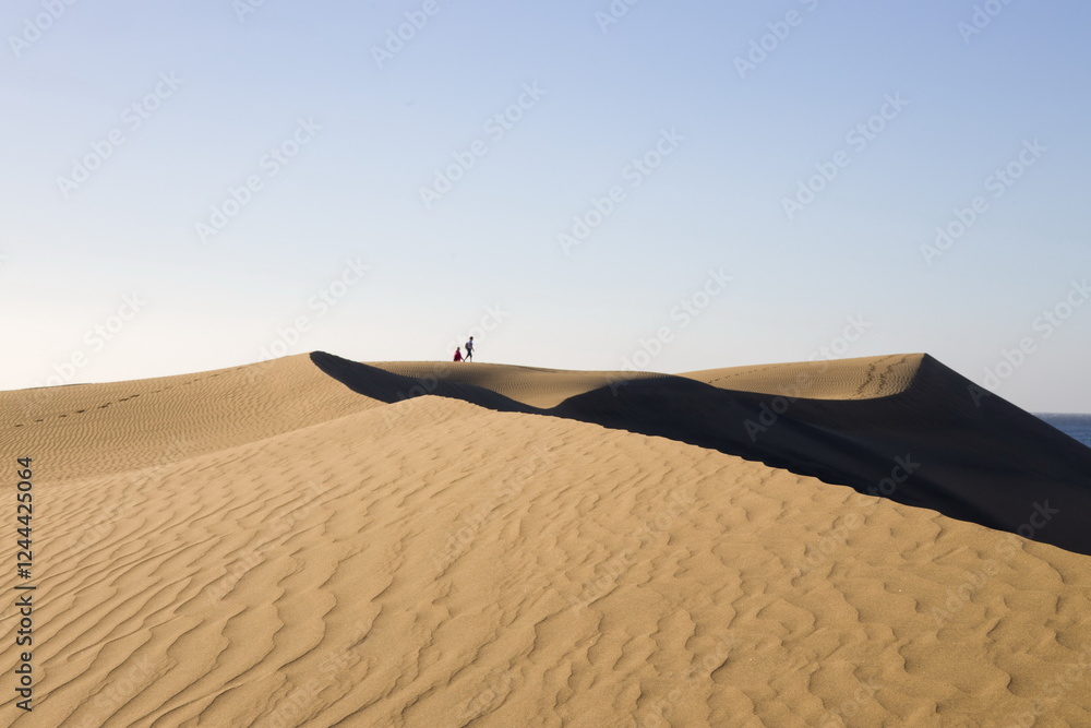 Maspalomas Dunes in Gran Canaria. Textured sand dunes with patterns, shadows, and faint footprints.