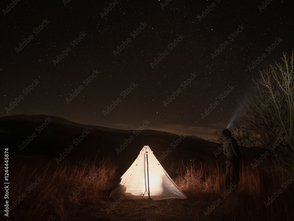 Φωτογραφία A hiker camping under the stars in Italy surrounded by mountains