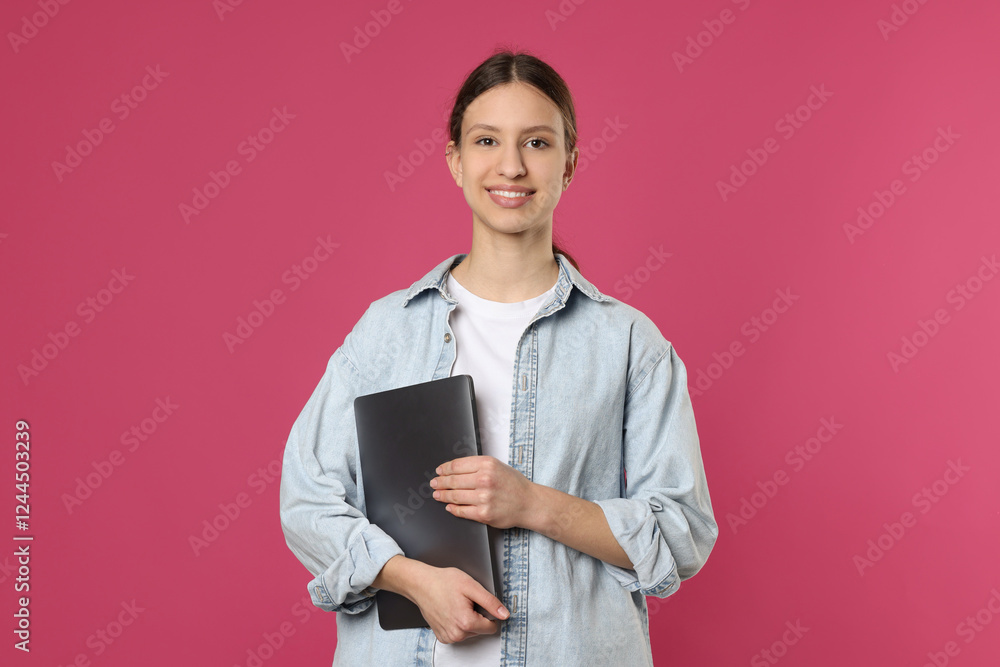 Portrait of smiling teenage girl with laptop on pink background Portrait of smiling teenage girl with laptop on pink background