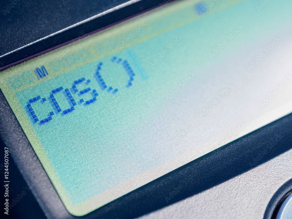 Calculator screen shows the cosine (cos) sign. Math trigonometry, function digital display, device calculation. Calculator screen shows the cosine (cos) sign. Math trigonometry, function digital display, device calculation.
