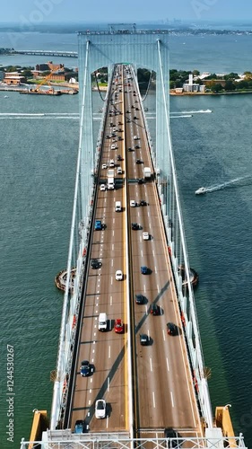 Flying along the six lane road on the Throgs Neck Bridge. Multiple boats float over the East River. photo