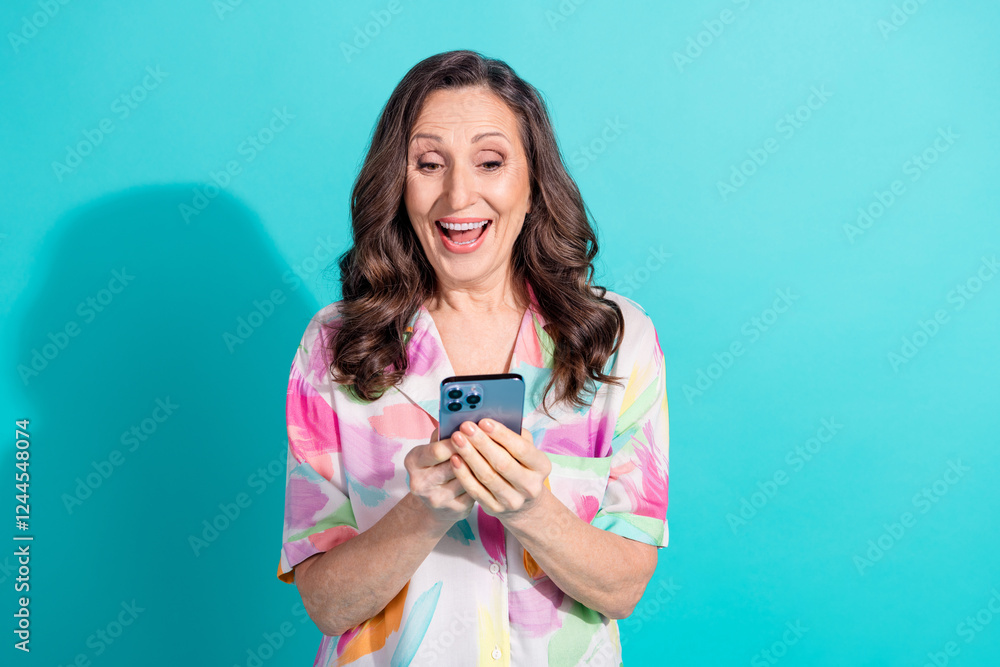 Photo portrait of pretty retired female hold device excited wear trendy colorful outfit isolated on cyan color background Photo portrait of pretty retired female hold device excited wear trendy colorful outfit isolated on cyan color background