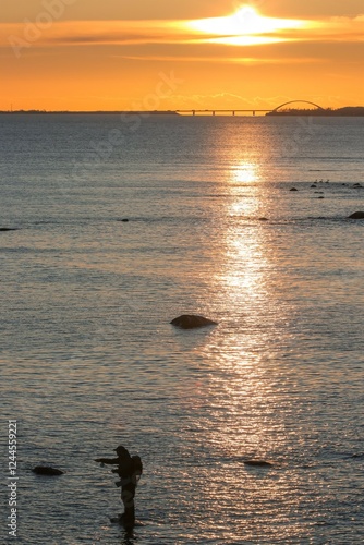 Obraz na płótnie Fligenfischen auf Meerforelle auf der Ostseeinsel Fehmarn am Riff von Staberhuk mit Fehmarn Sund Brücke im Hintergrund. w salonie
