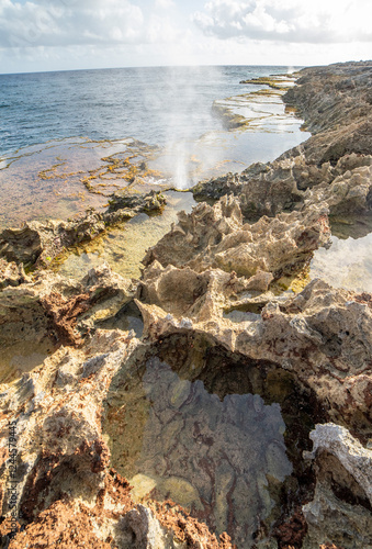 blowhole on beach with tropical background 