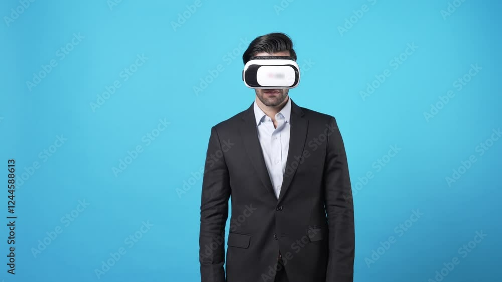 Skilled businessman holding hologram while checking financial data and standing at blue background. Skilled investor looking at statistic chart hologram while planning marketing strategy. Apparatus. Skilled businessman holding hologram while checking financial data and standing at blue background. Skilled investor looking at statistic chart hologram while planning marketing strategy. Apparatus.