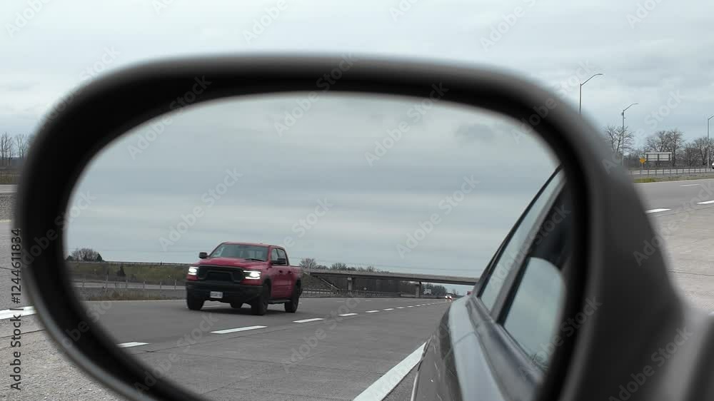 Driver Side Mirror Reflecting Traffic on a Cloudy Highway