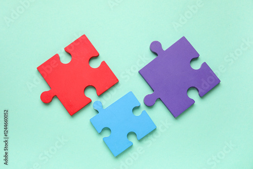 Colorful puzzle pieces on turquoise background. Concept of autistic disorder. Top view photo