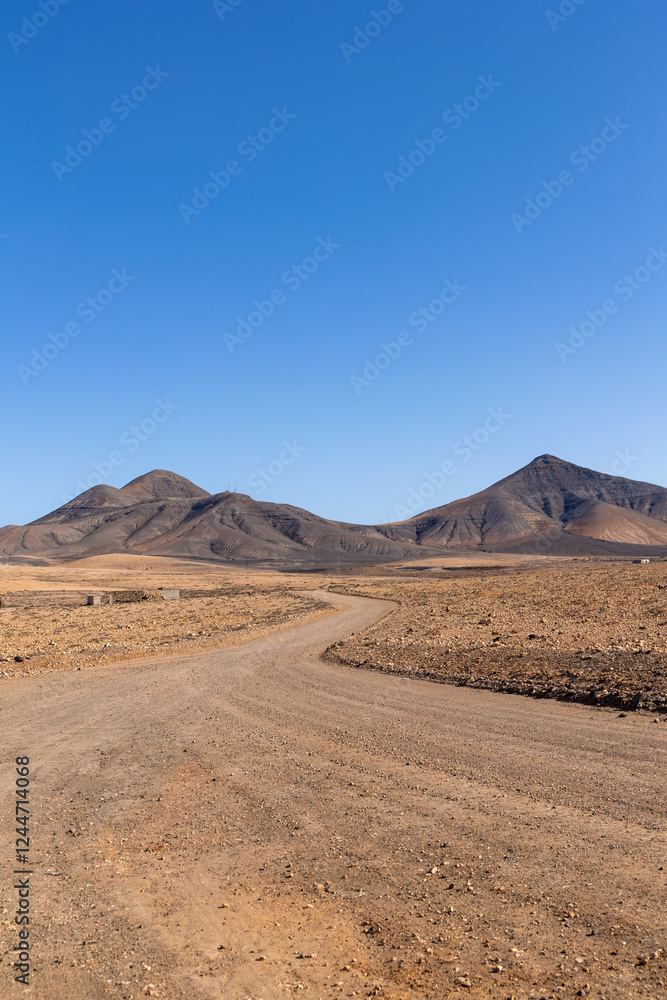 Strange, lunar landscape of the Fuerteventura volcanos and dirt roads in the interior of the island. Mountains, sands Strange, lunar landscape of the Fuerteventura volcanos and dirt roads in the interior of the island. Mountains, sands