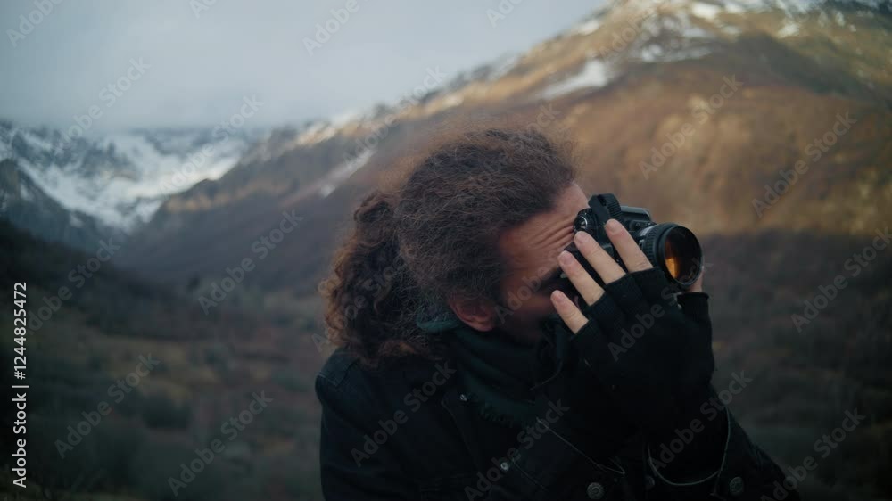 Man with Long Hair Adjusting Camera Settings and Taking Picture in Mountains Man with Long Hair Adjusting Camera Settings and Taking Picture in Mountains